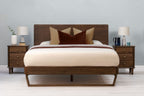Mayfair solid walnut double bed frame with floating sled leg, front view from the foot of the bed with matching bedside tables