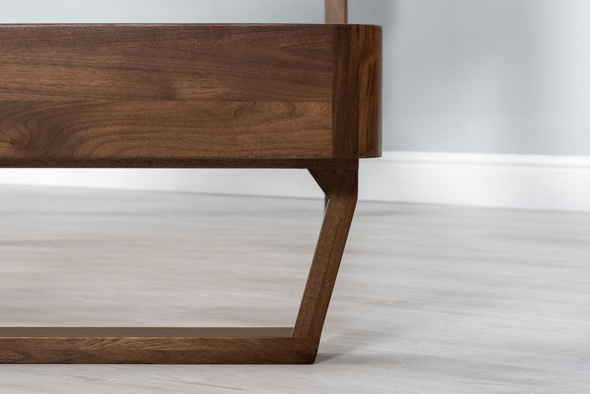 Mayfair solid walnut double bed frame, side-on close-up of the solid oak sled leg beneath the rounded foot-end corner
