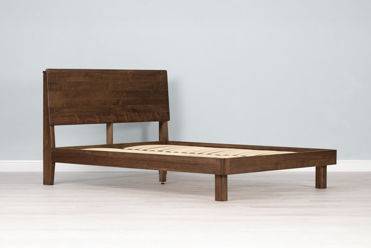 Mayfair solid walnut double bed frame with square legs and no mattress, angled view showing the slatted base