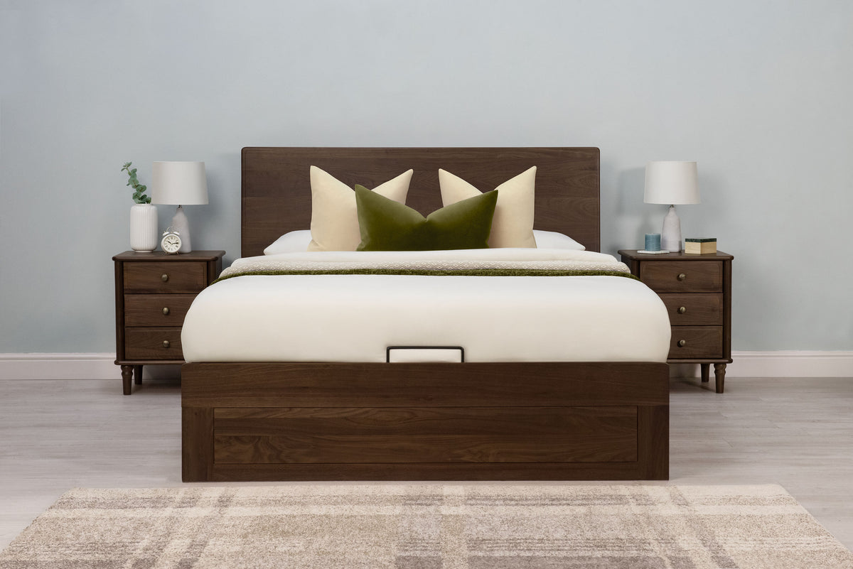 Mayfair solid walnut double ottoman bed frame, front view from the foot of the bed with matching walnut bedside tables