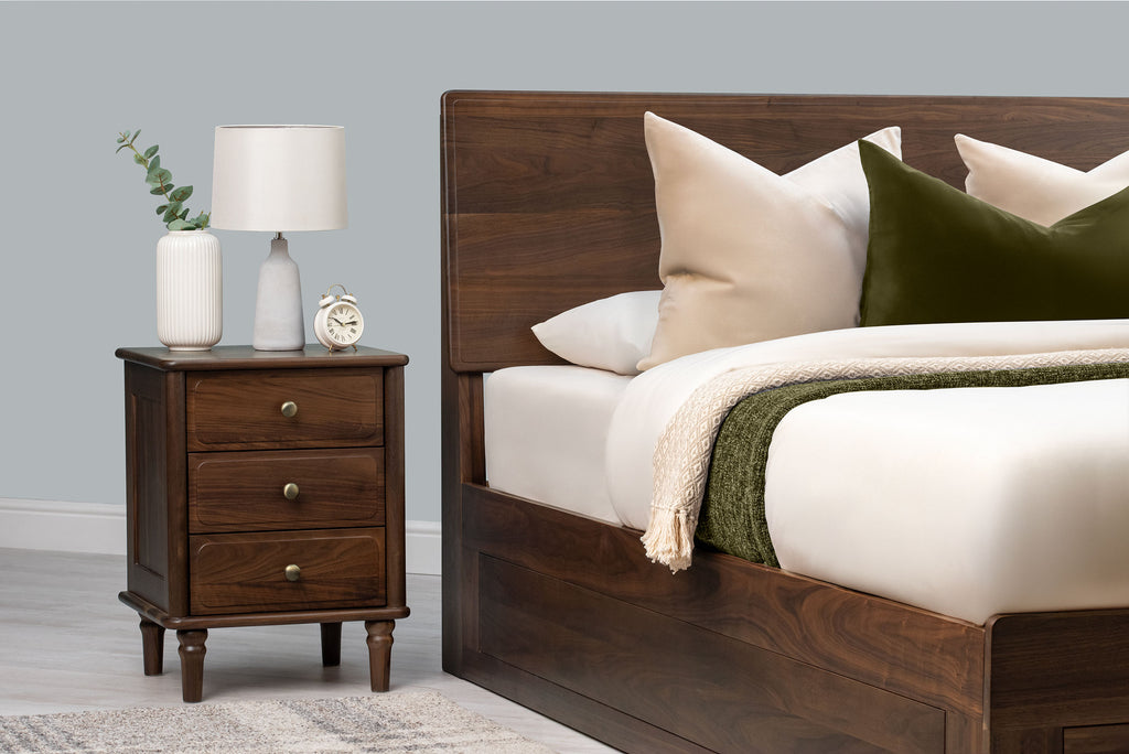 Mayfair solid walnut double ottoman bed headboard with cream and green bedding and a matching three-drawer bedside table