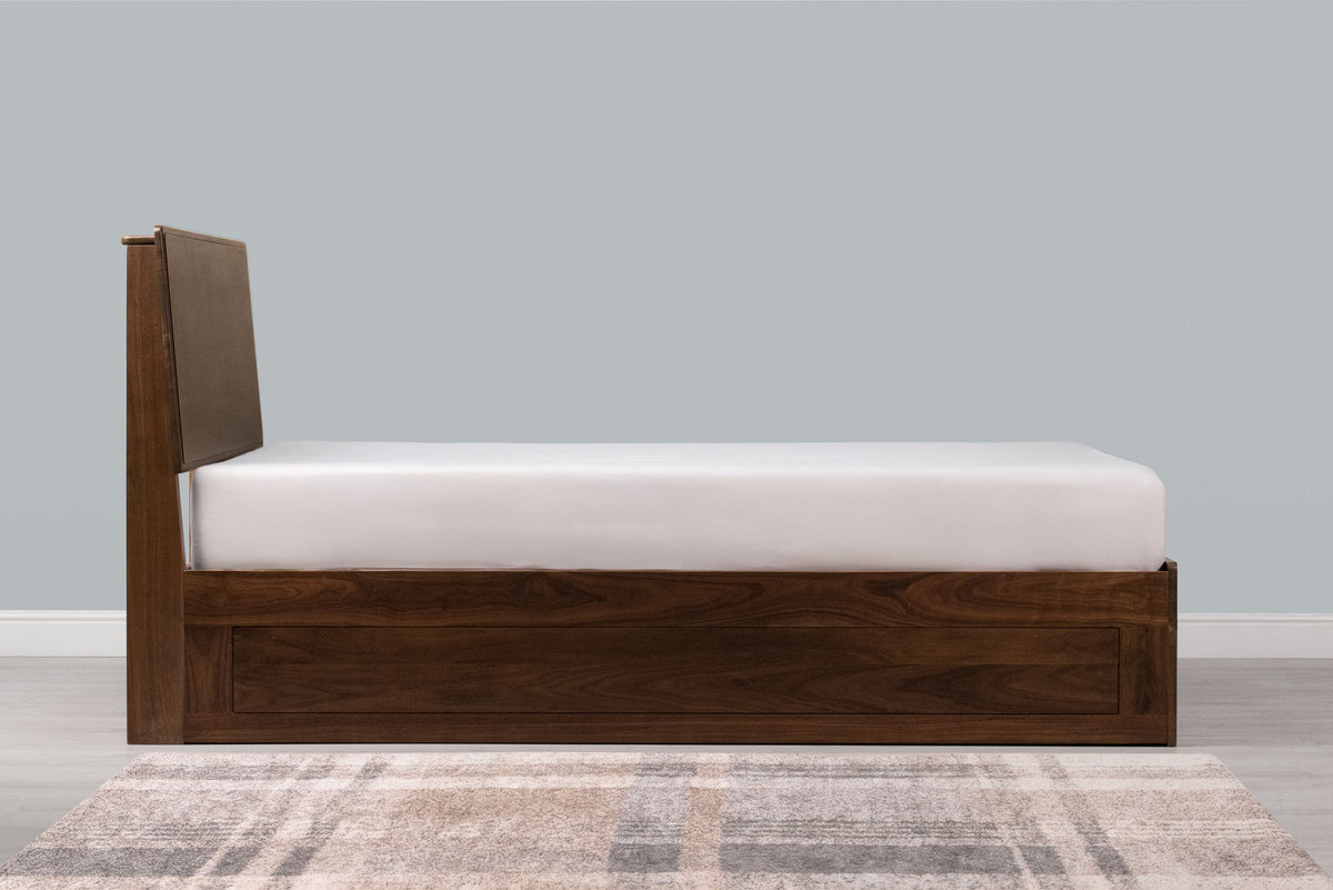 Mayfair solid walnut double ottoman bed frame with a bare mattress, side view showing the panelled side rail