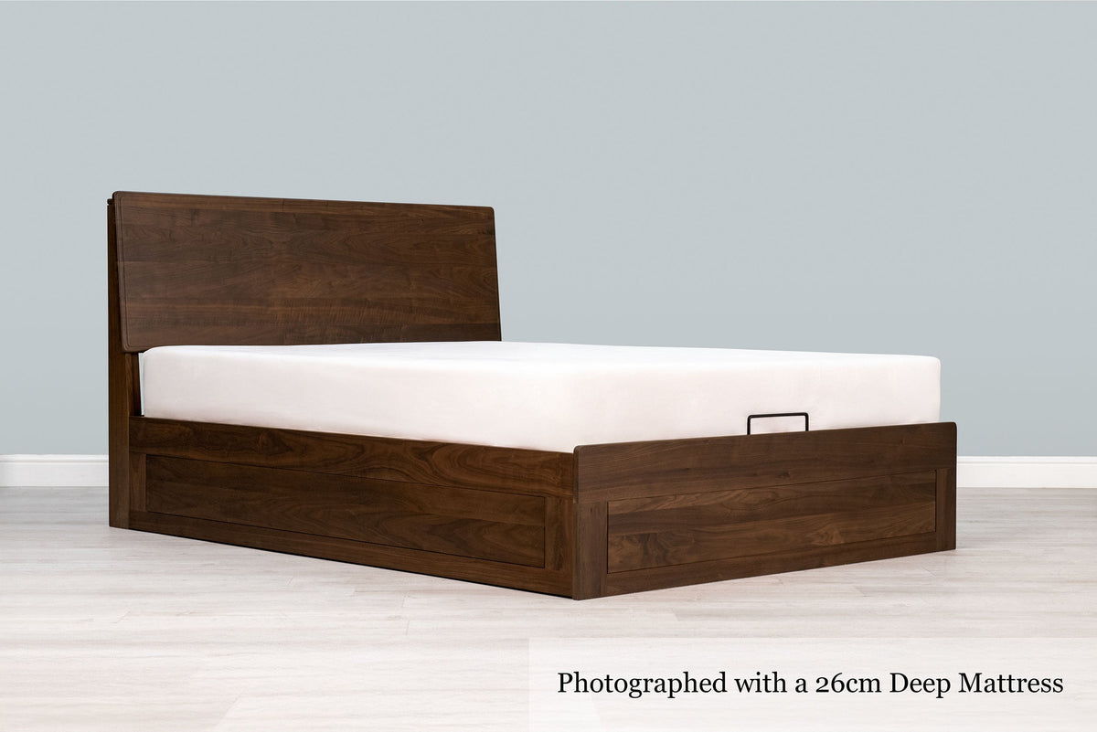 Mayfair solid walnut king size ottoman bed frame with a 26cm deep mattress and no bedding, angled view