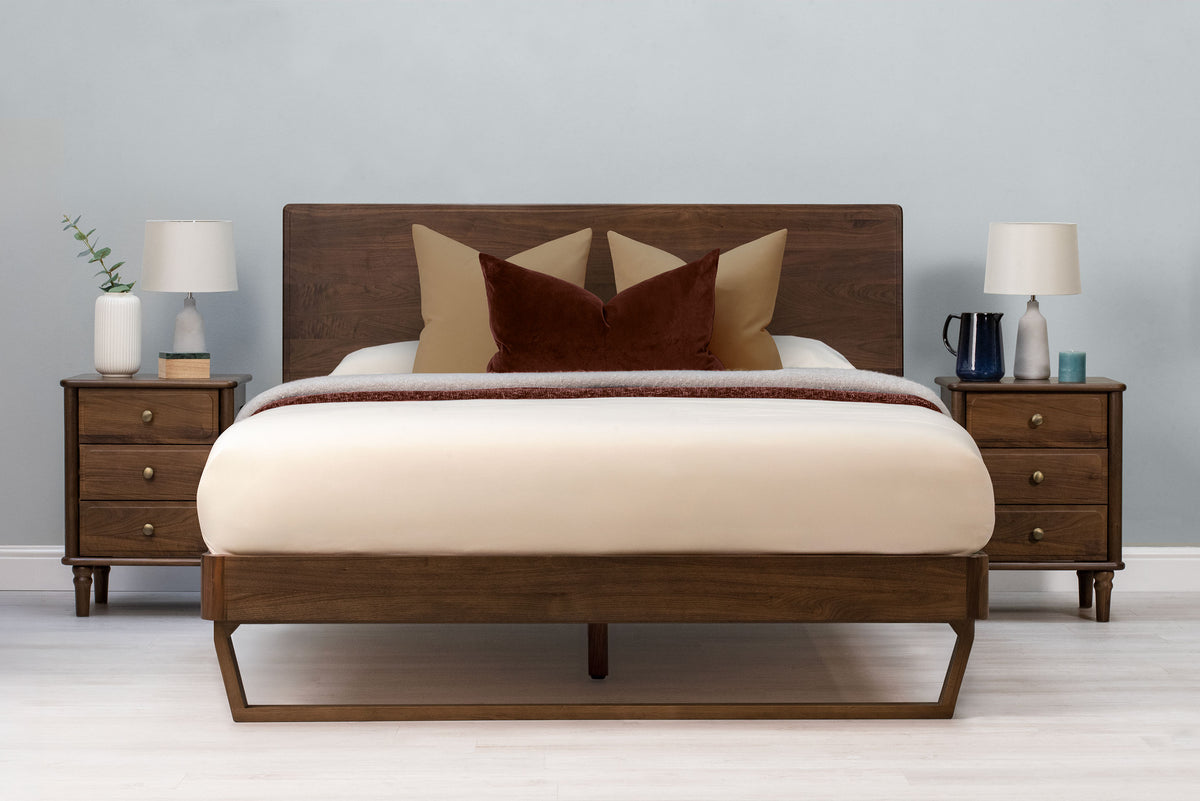 Mayfair solid walnut super king bed frame with floating sled leg, front view from the foot of the bed with matching bedside tables