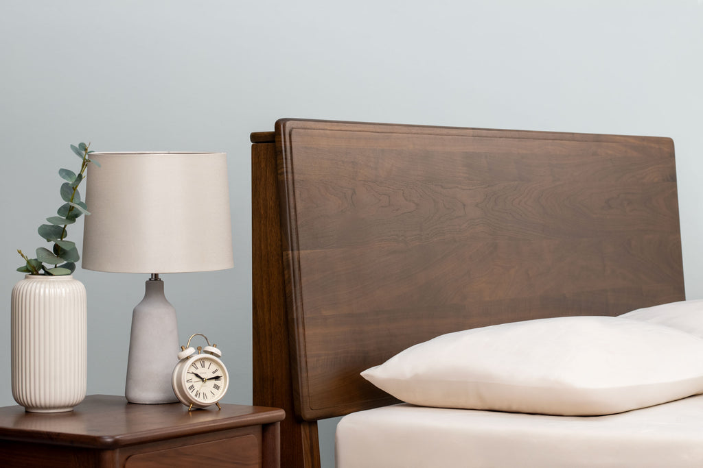 Mayfair solid walnut super king bed headboard at its lowest height setting, beside a matching walnut bedside table