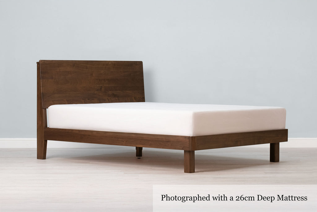 Mayfair solid walnut super king bed frame with square legs, a 26cm deep mattress and no bedding, angled view