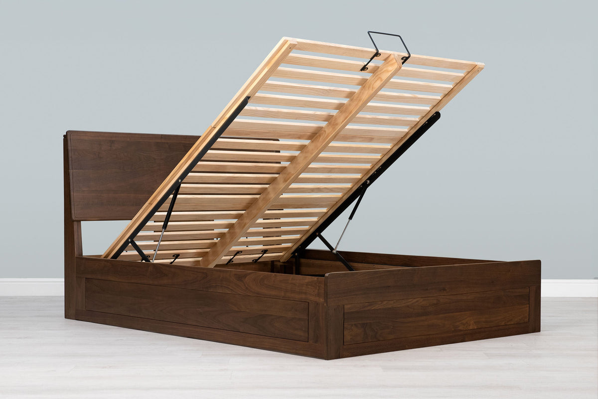 Mayfair solid walnut super king ottoman bed frame without a mattress, with the slatted base raised on gas-lift struts
