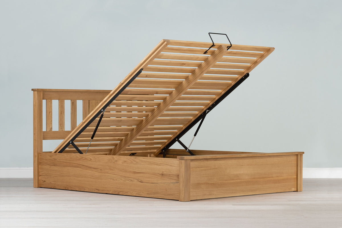 Wilmore solid natural oak king size ottoman bed frame without a mattress, with the slatted base raised on gas-lift struts