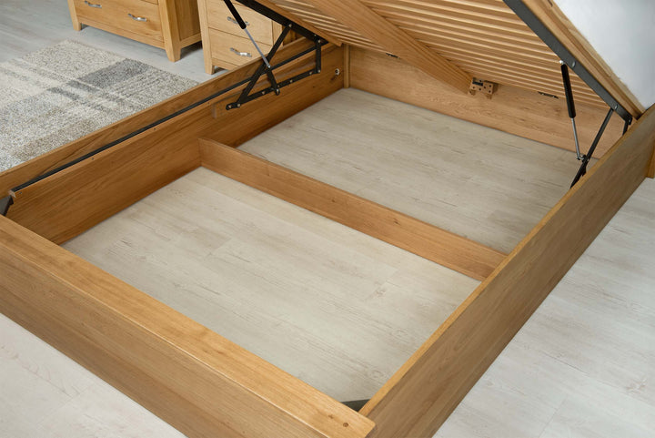 Wilmore solid natural oak super king ottoman bed storage area with the removable base panels taken out, showing the floor beneath