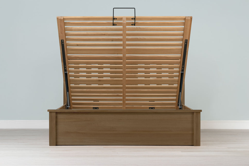 Wilmore solid rustic oak super king ottoman bed frame without a mattress, front view with the slatted base fully raised