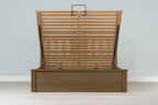 Wilmore solid rustic oak super king ottoman bed frame without a mattress, front view with the slatted base fully raised