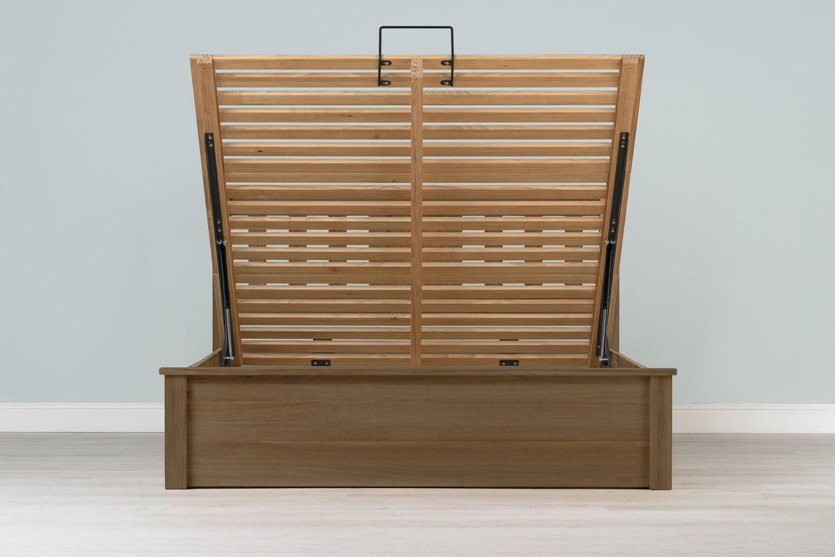 Wilmore solid rustic oak super king ottoman bed frame without a mattress, front view with the slatted base fully raised