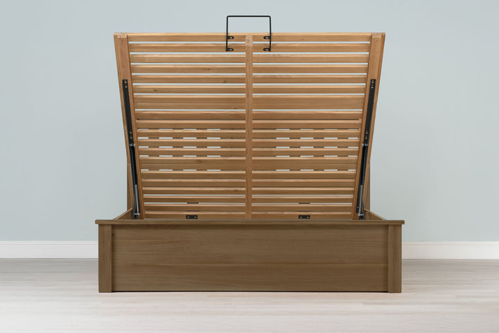 Wilmore solid rustic oak super king ottoman bed frame without a mattress, front view with the slatted base fully raised