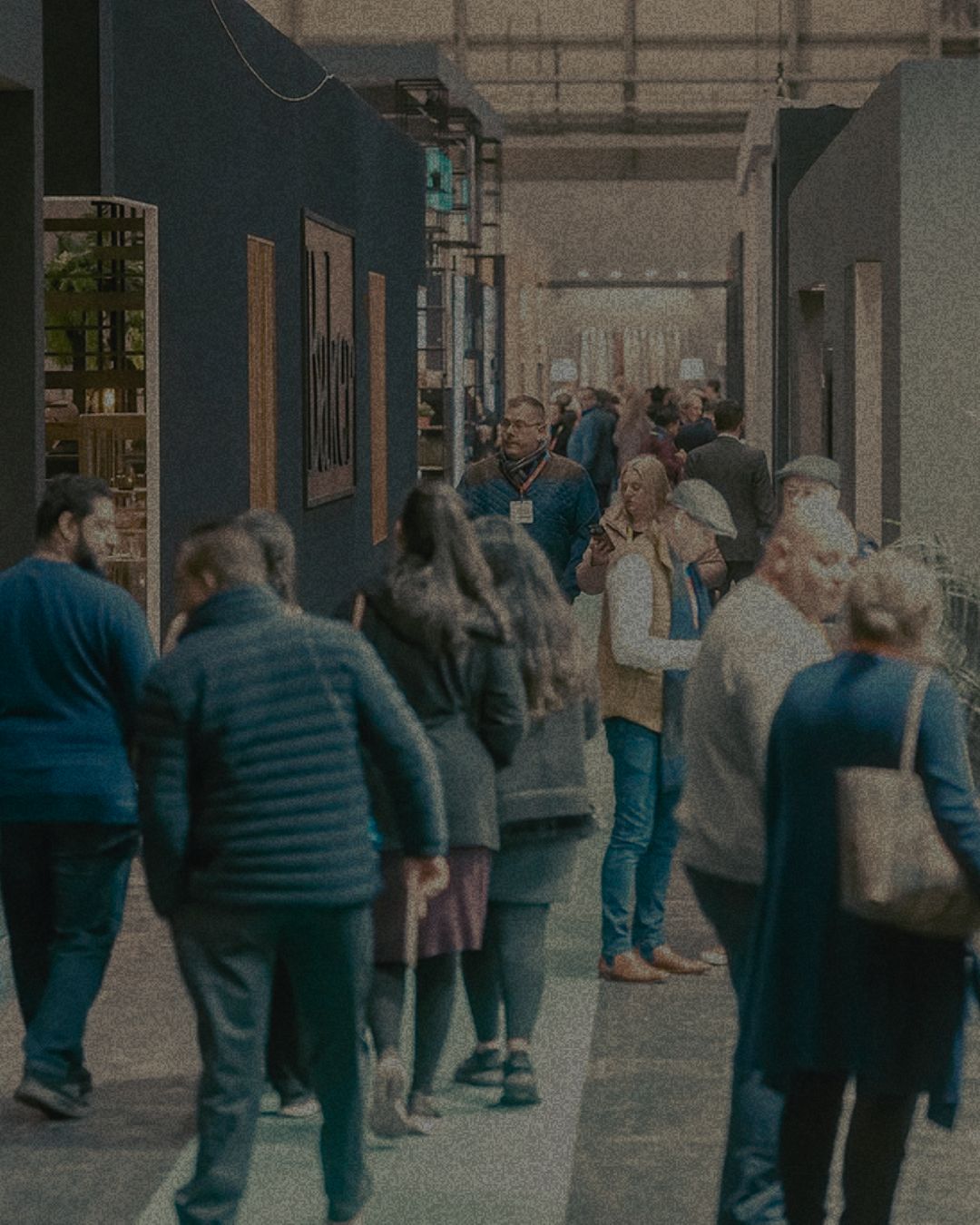 Visitors walking the aisles of a furniture trade show