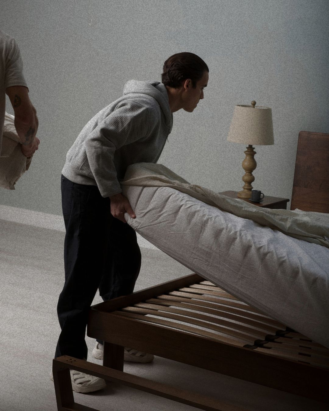 Lifting a mattress to check the slats of a solid oak bed frame